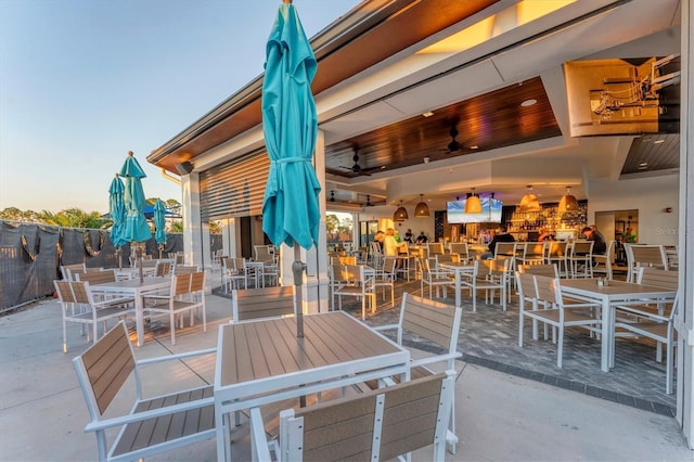 view of patio featuring outdoor dining area, fence, and ceiling fan