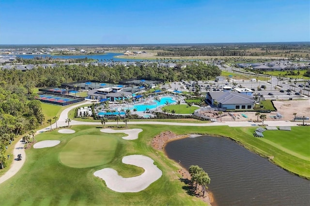 drone / aerial view featuring golf course view and a water view