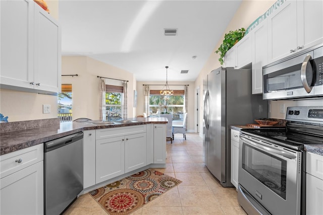 kitchen with light tile patterned floors, visible vents, a peninsula, a sink, and stainless steel appliances