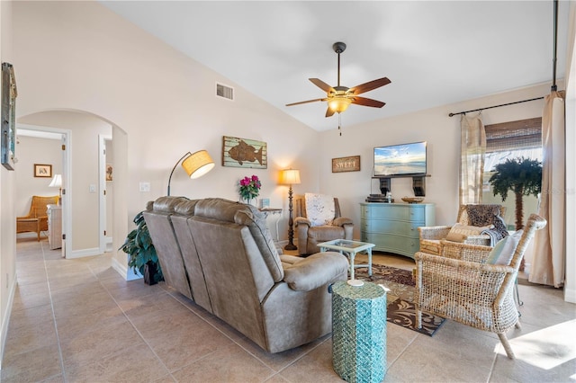 living area featuring light tile patterned floors, a ceiling fan, visible vents, arched walkways, and vaulted ceiling