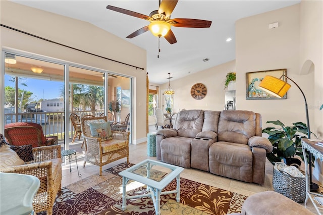 living room featuring light tile patterned flooring, visible vents, ceiling fan, and lofted ceiling