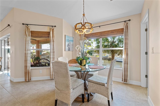 dining space featuring an inviting chandelier, light tile patterned floors, and baseboards