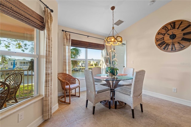 dining space with light tile patterned floors, visible vents, baseboards, and a chandelier