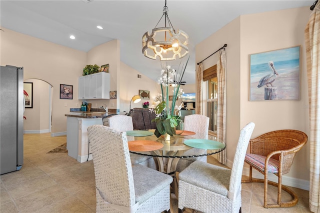 dining room featuring baseboards, an inviting chandelier, lofted ceiling, recessed lighting, and arched walkways