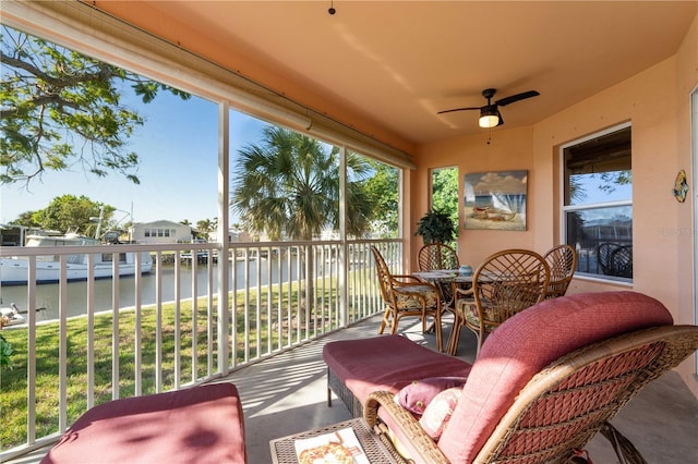 balcony featuring a water view and ceiling fan