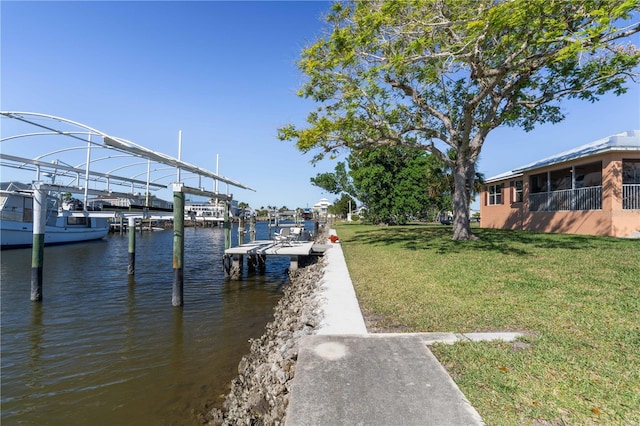 view of dock with a yard and a water view