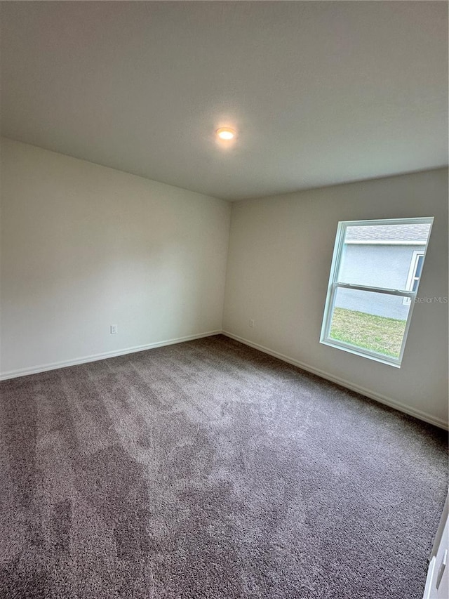 unfurnished room with baseboards and carpet