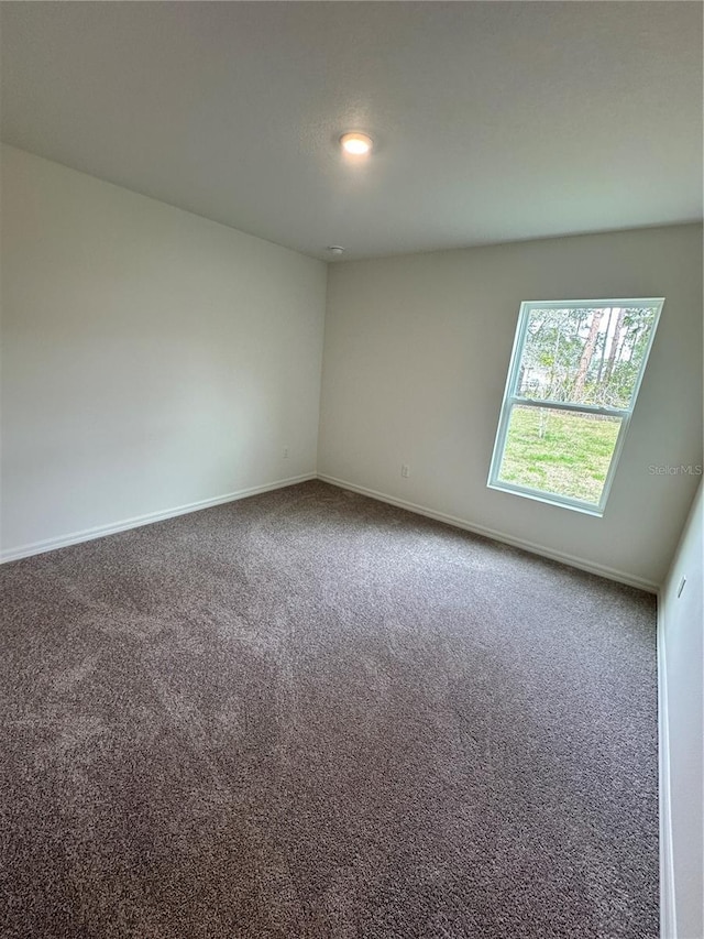spare room with carpet flooring and baseboards