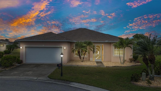 single story home with a garage, driveway, a front lawn, and stucco siding