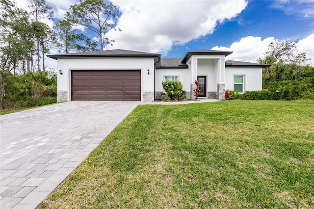 prairie-style house featuring stucco siding, a front yard, and a garage