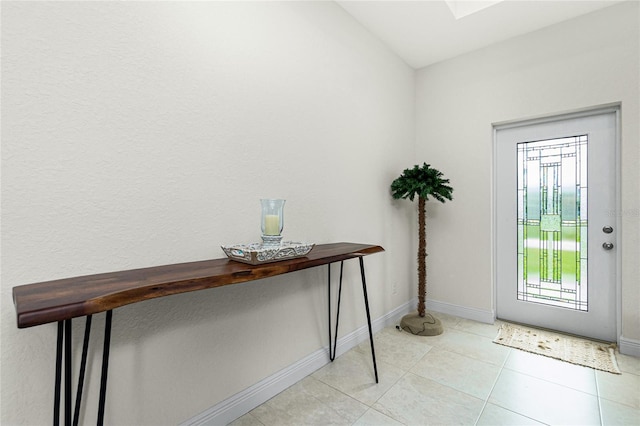 entryway with light tile patterned floors, baseboards, and a skylight