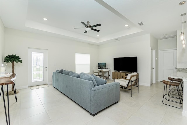 living room featuring visible vents, recessed lighting, and a tray ceiling