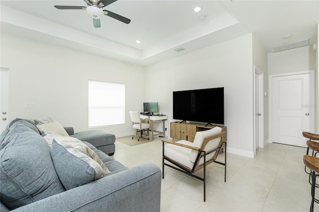 living room with light tile patterned floors, baseboards, visible vents, recessed lighting, and a raised ceiling