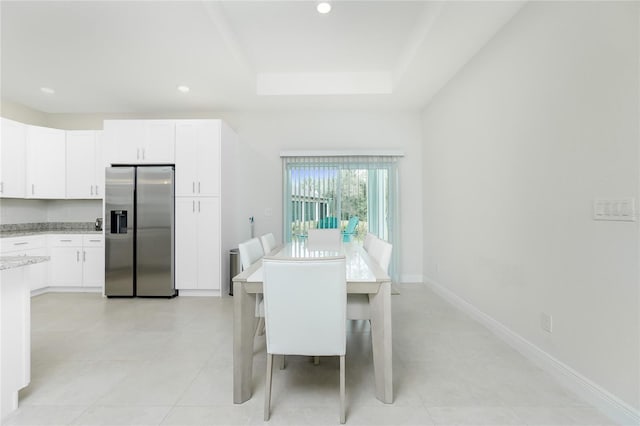 dining space featuring a tray ceiling, recessed lighting, and baseboards