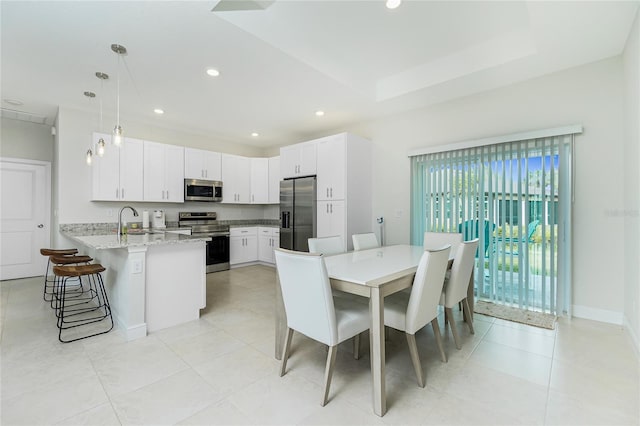 dining room featuring a tray ceiling, light tile patterned flooring, recessed lighting, and baseboards