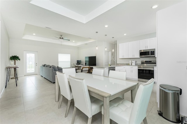 dining space featuring a tray ceiling, recessed lighting, and visible vents