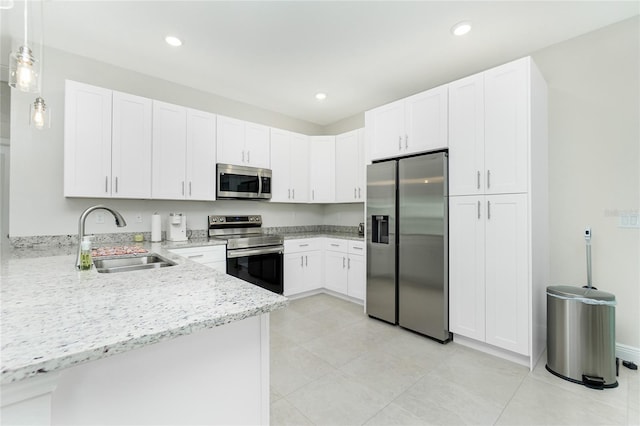 kitchen featuring light stone counters, recessed lighting, stainless steel appliances, white cabinetry, and a sink