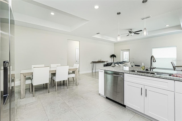 kitchen featuring visible vents, a tray ceiling, stainless steel dishwasher, white cabinets, and a sink