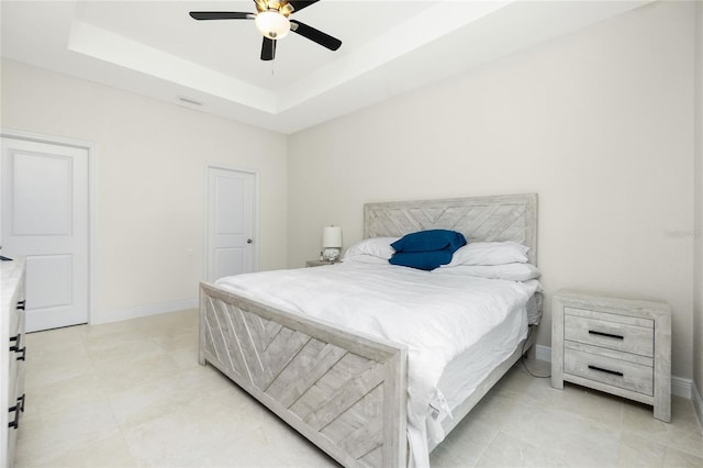 bedroom featuring visible vents, a ceiling fan, a tray ceiling, light tile patterned floors, and baseboards