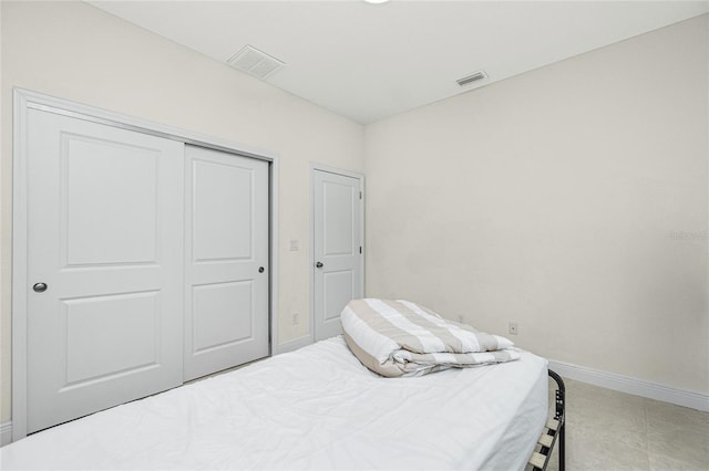 bedroom with a closet, visible vents, and baseboards