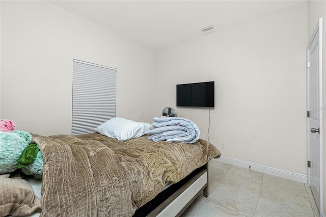 bedroom with light tile patterned floors, visible vents, and baseboards