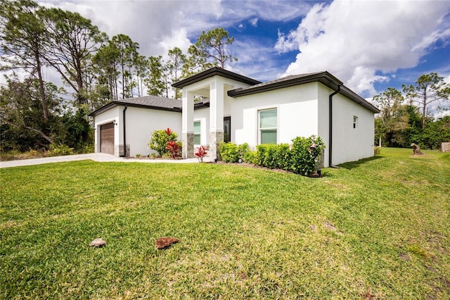 view of front of house with stucco siding, an attached garage, driveway, and a front lawn