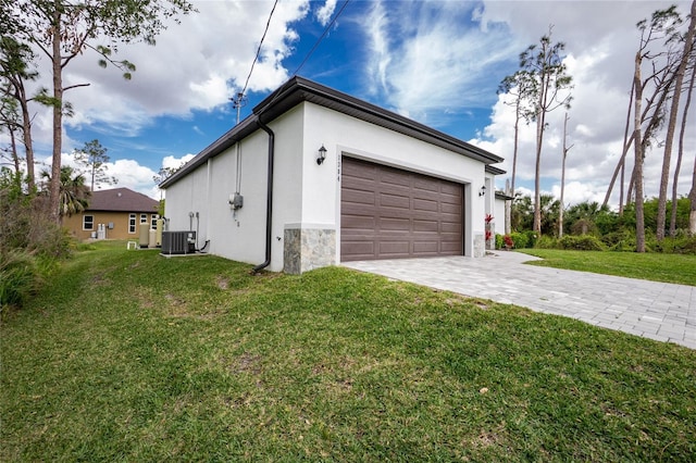 garage featuring decorative driveway and central AC unit