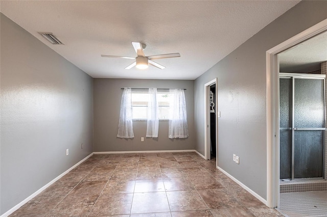 empty room featuring visible vents, a textured ceiling, baseboards, and ceiling fan