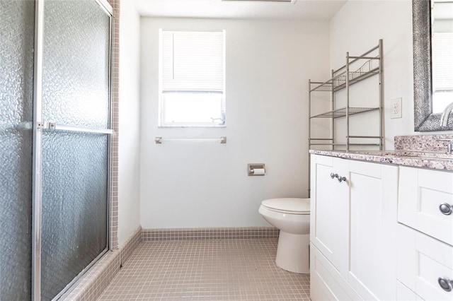 bathroom featuring tile patterned flooring, a shower stall, toilet, and vanity