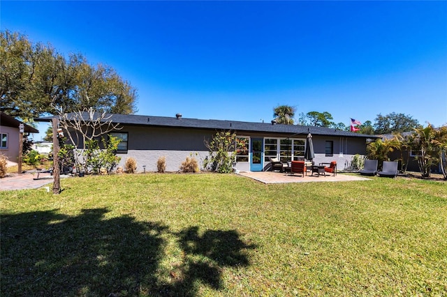 back of property featuring a patio area, stucco siding, and a yard