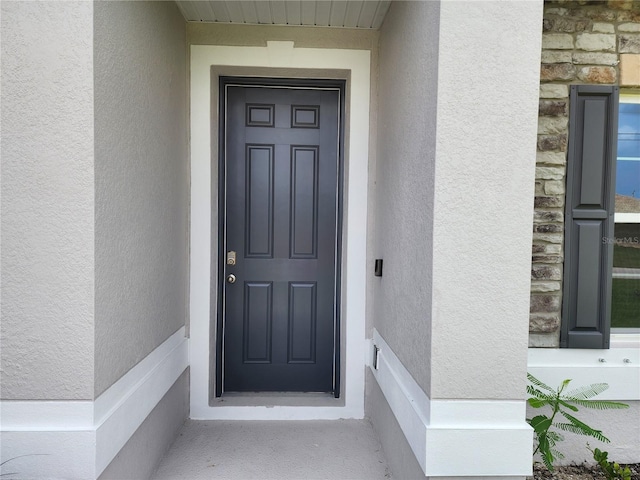 property entrance featuring stucco siding