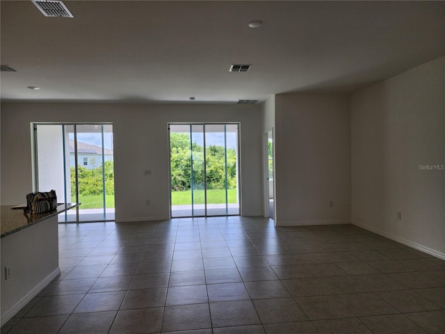 tiled spare room with visible vents and baseboards