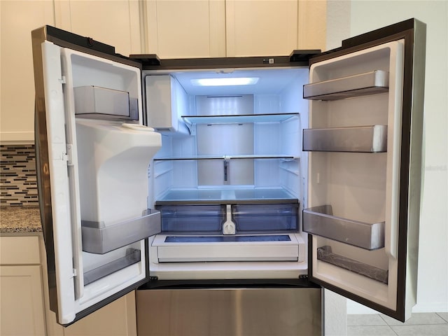 details featuring backsplash, light stone countertops, white cabinetry, fridge, and open shelves