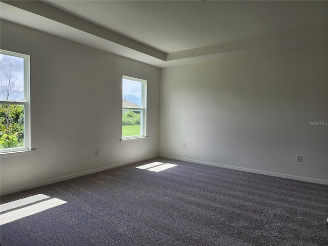 empty room with dark colored carpet and baseboards