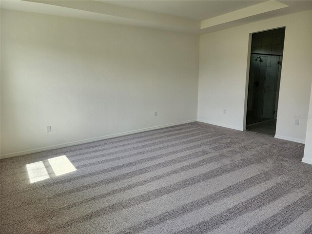 unfurnished bedroom with dark colored carpet and baseboards