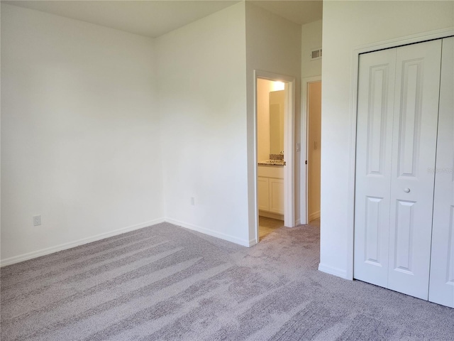 unfurnished bedroom with a closet, visible vents, baseboards, and carpet floors