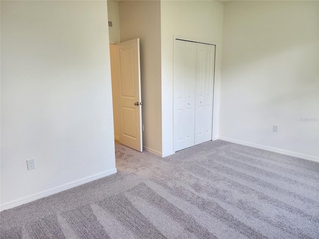 unfurnished bedroom with a closet, baseboards, carpet, and visible vents