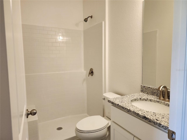 full bath with a shower stall, vanity, toilet, and a textured wall