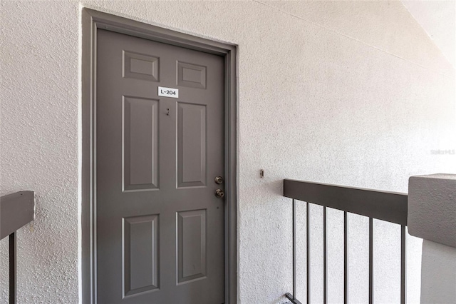 entrance to property featuring stucco siding