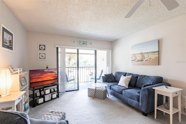 living room featuring light colored carpet, a ceiling fan, and a textured ceiling