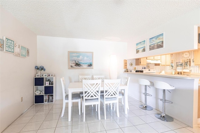 dining space with light tile patterned floors and a textured ceiling