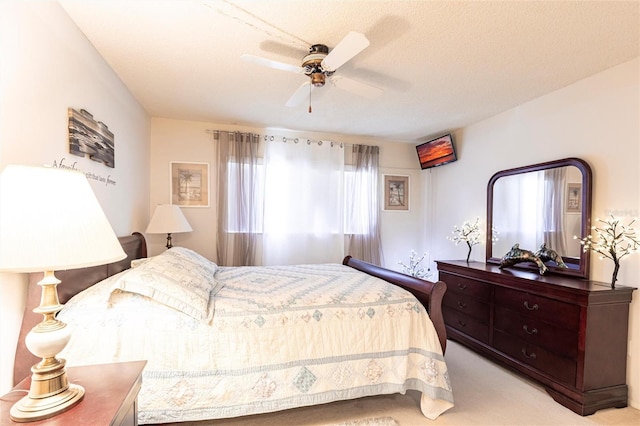 bedroom with a ceiling fan, carpet, and a textured ceiling