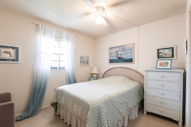 carpeted bedroom with ceiling fan, baseboards, and a textured ceiling