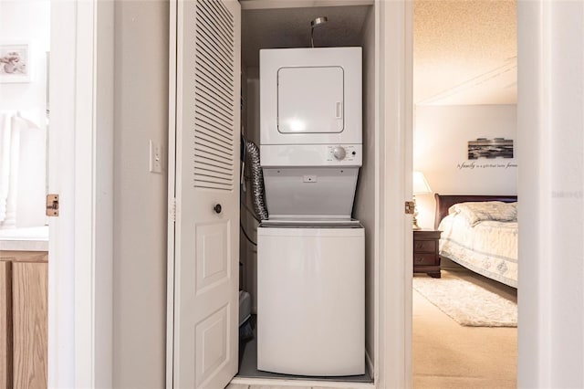 clothes washing area featuring laundry area and stacked washer and dryer