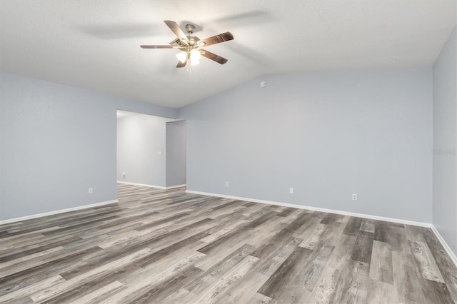 unfurnished room with wood finished floors, a ceiling fan, baseboards, and lofted ceiling