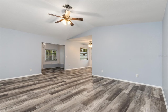 empty room with visible vents, a ceiling fan, wood finished floors, baseboards, and lofted ceiling