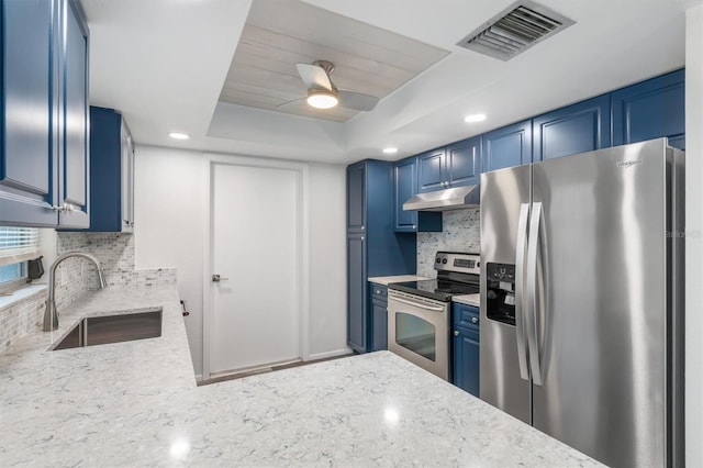 kitchen with visible vents, blue cabinetry, stainless steel appliances, a raised ceiling, and a sink