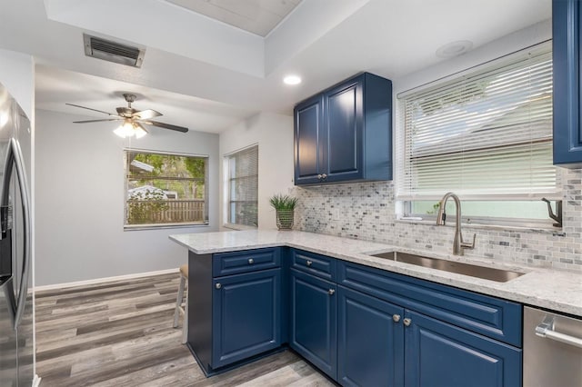 kitchen with a sink, visible vents, tasteful backsplash, and stainless steel appliances