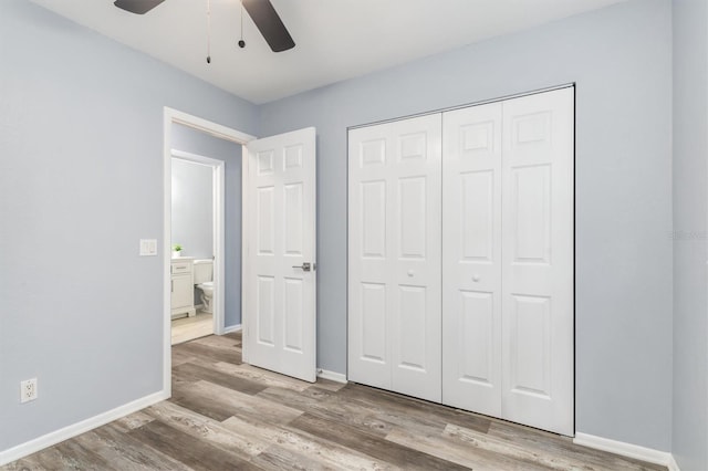 unfurnished bedroom featuring a ceiling fan, wood finished floors, baseboards, and a closet