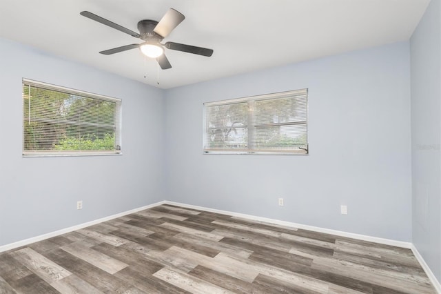 empty room with a healthy amount of sunlight, ceiling fan, baseboards, and wood finished floors